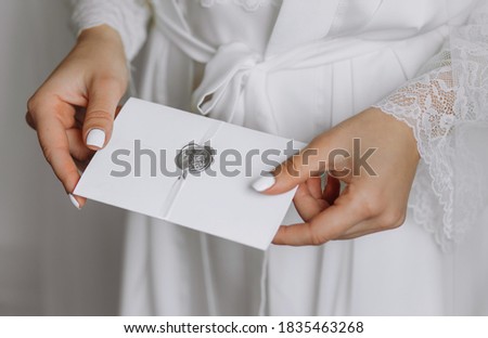 Wedding invitation in the hands of the bride