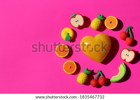 Heart and fruits on pink background. Healthy eating. Self care. 