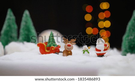 Santa Claus, snowman, deer. Santa Claus with a deer and a snowman on the background of light bulbs.