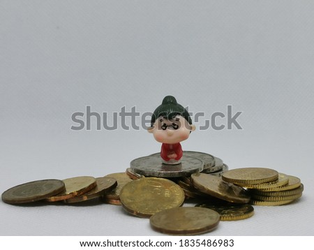 Photo of coins and miniature old woman isolated on white background.Money and finance concept.Life savings.Selective focus.