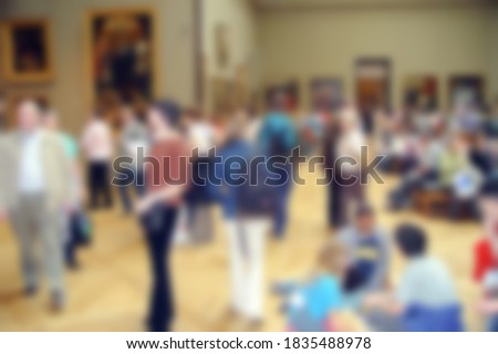 Defocused photography. people in the art gallery look at paintings. Blurred background copy space for your design