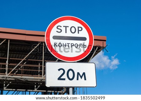 Traffic control sign in front of checkpoint gate with inscription "stop control" in Russian