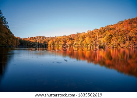Beautiful fall pictures displaying beautiful autumn scenes with colorful red and yellow leaves, motion blur water, with amazing reflection in the water.