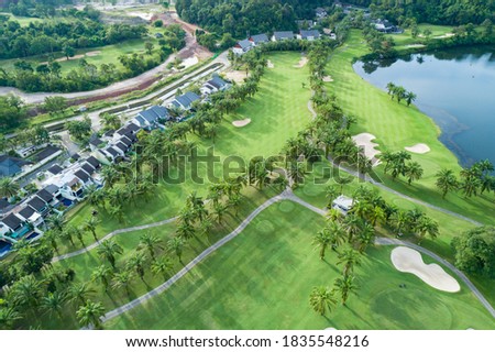 Aerial view drone Top down shot of beautiful green golf field with modern villa High angle view in summer time