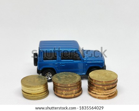 Photo of coins and miniature car isolated on white background.Money and finance concept.Vehicle loan and expences.Selective focus.