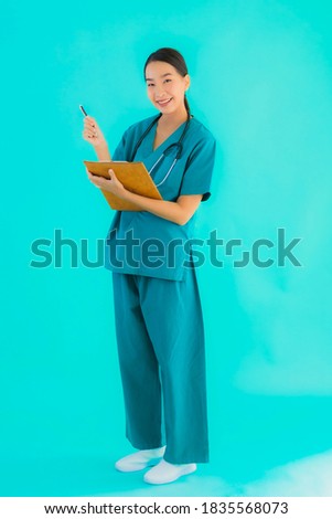 Portrait beautiful young asian doctor woman with empty paper board for copy space on blue isolated background - Healthcare in hospital and clinic concept
