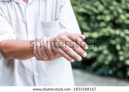Patients elderly wrist pain hands, due to a nervous system illness and paralysis, On blur background, to health care concept. Royalty-Free Stock Photo #1835588167