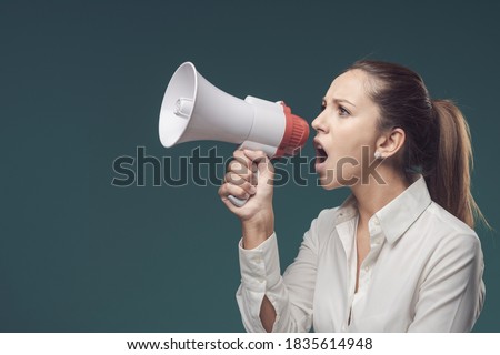 Angry bossy woman giving orders through a megaphone, communication and marketing concept Royalty-Free Stock Photo #1835614948