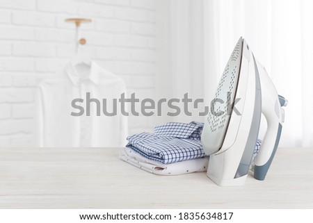 Iron on wooden board with clothes, ironing board household concept Royalty-Free Stock Photo #1835634817