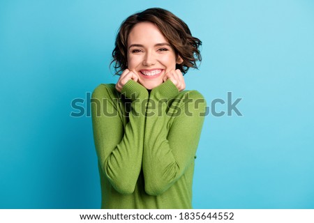 Portrait of nice attractive charming girl touch hands face enjoy weekend, wear green style stylish trendy clothes isolated over blue color background