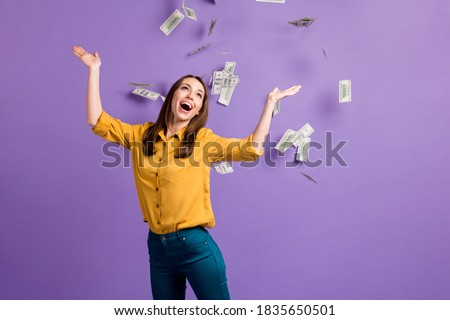 Photo of cute crazy young lady raise arms open mouth cash rain wear yellow shirt isolated violet color background.