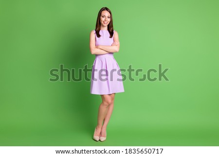 Full body photo of gorgeous smiling girl lady crossed hands slim legs flirty stand posing, advert recruiting agency wear violet dress beige shoes isolated pastel green color background
