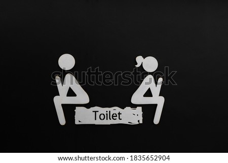 Male and female restroom symbols, with an English letter indicating "Toilet ", isolated on black background.