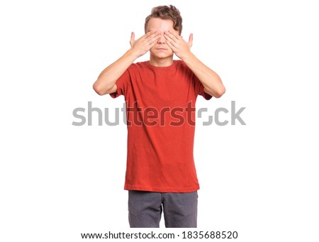 Handsome teen boy with sad expression covering face with hands while crying, isolated on white background