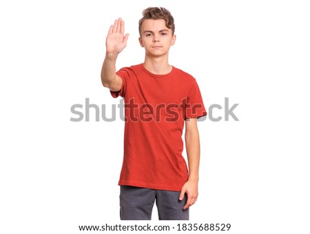 Handsome teen boy showing stop gesture with his palm, isolated on white background