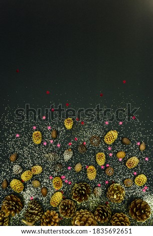 Christmas decoration with cones and glitter on a black background