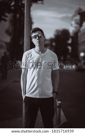Guy stand on the city street, look camera and around