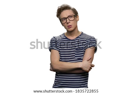 Portrait of smart thoughtful nerdy guy with folded arms. Intelligent teen boy against white background.