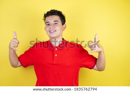 Beautiful teenager boy over isolated yellow background shouting with crazy expression doing rock symbol with hands up