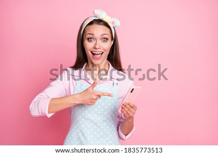 Close-up portrait of her she nice attractive amazed cheerful glad brown-haired housewife holding in hands device demonstrating, like look idea comment follower isolated pink pastel color background
