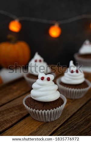 Halloween ghost cupcakes , homemade sweet chocolate muffins with meringue ghost