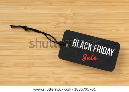 Sale tag with Black Friday written on wooden background for Black Friday concept