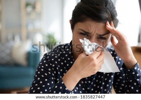 Close up image sick indian woman feels unwell blowing her nose into paper napkin reducing breathing relief discomfort. Nasal mucosa inflammation, viruses infection and seasonal pollen allergy concept Royalty-Free Stock Photo #1835827447