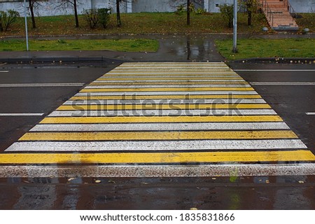 a pedestrian crossing wet from the rain