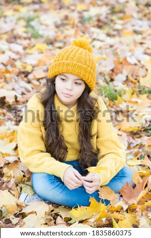 No rush. beauty of fall nature. happy kid wear knitted sweater and hat. teen girl relax among fallen leaves. child walk in autumn forest. warm clothes fashion. seasonal weather. childhood.