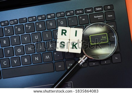 Text on risk on cubes with magnifying glass magnifies the laptop keyboard button