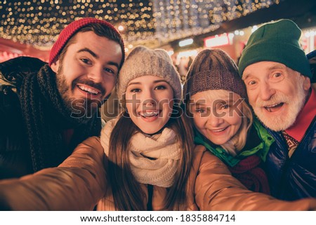Closeup photo of full family four members x-mas gathering meeting, take selfie portrait cheerful smile wear outerwear hat scarf coat two generation night street illumination outdoors outside
