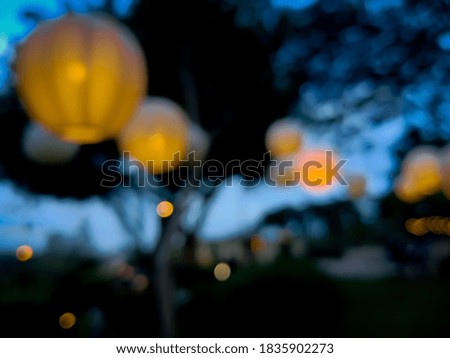 Blurred background A collection of orange lanterns in a park with tall trees. Very beautiful and romantic