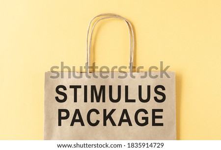 STIMULUS PACKAGE text on paper package on yellow background. Business and Copy space concept.