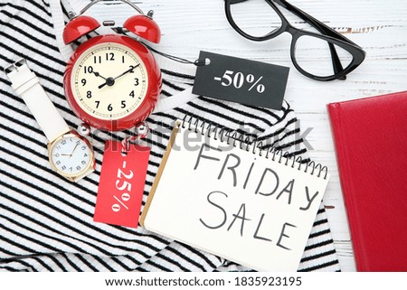 Inscription Friday Sale, striped T-shirt, notepad, tags and watches on wooden background