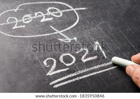 Closeup hand writing numbers of change year from 2020 to 2021 on blackboard, focus at future or coming year 2021