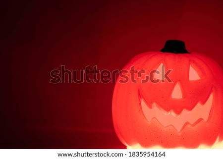 halloween glowing pumpkin scary head on red background.