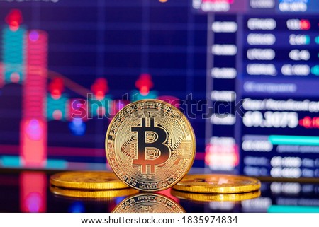 Gold Bitcoin crypto currency on background of chart diagram.