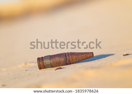 old rusty bullet lie on a sand, military war background