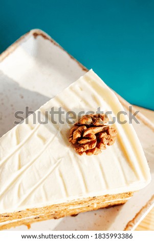 walnut slice of cake on a square plate with mint and walnuts