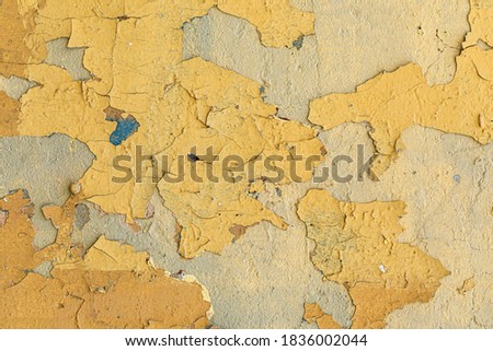 old crumbling plaster on a yellow wall.