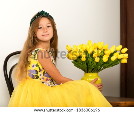 Little girl with a bouquet of tulips.The concept of the awakening of nature after winter