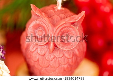 Handmade honey candles made of natural wax in the form of owl on a pink background. Elements from natural materials. Christmas or New Year composition. Photo for postcards.