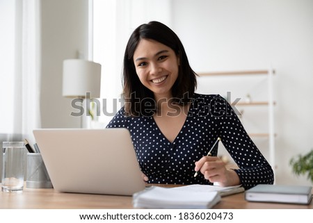 Portrait of smiling young asian female student study online or take web course training on computer. Happy Vietnamese woman make notes work on laptop from home office. Distant education concept. Royalty-Free Stock Photo #1836020473