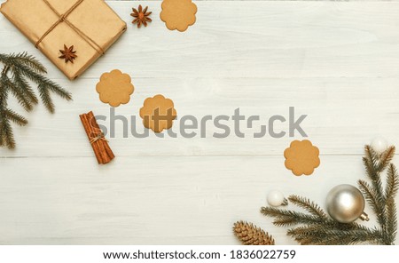 Christmas background with fir branches, gift in craft paper, ginger cookies and star anise. Top view with space, on a light background