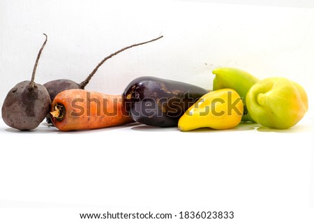 Still life - vegetables from the garden, orange carrots, dark red beets, purple eggplant, green sweet pepper on a white background. 