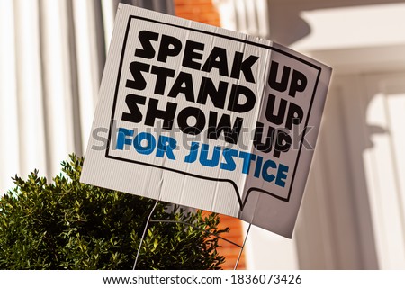 An anonymous yard sign that says: "Stand up, speak up, show up for justice" referring to recent events  related to racism, discrimination and civil liberties, that lead to social unrest in USA.