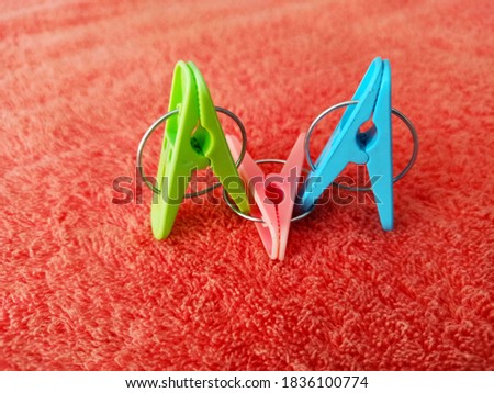 Clothes pins - Green, pink and blue plastic clothespins on a pink background.