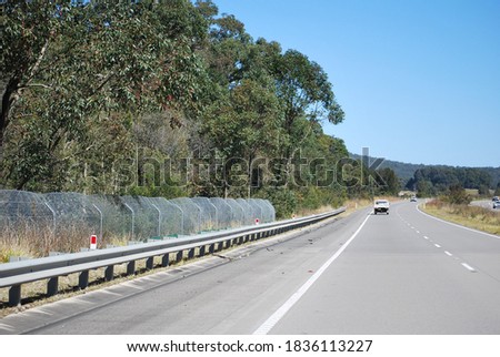 View of the fence that protects animals from being run over by cars on the Pacific highway near Forster, Australia