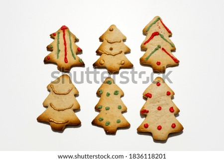 Homemade Christmas gingerbread cookies isolated on white background. Pine-shaped cookies. Decorated Christmas cookies