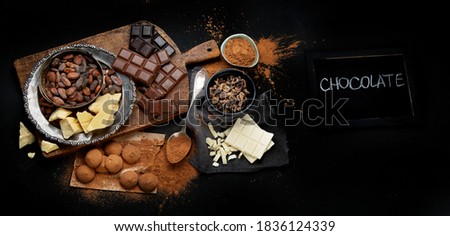 Delicious chocolate bars and pieces. Top view, copy space, chalkboard. Panorama, banner
